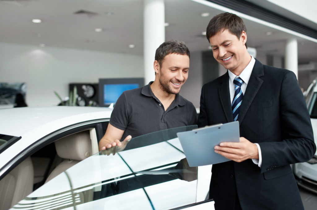Two gentlemen discussing a car sale inside a car dealership.