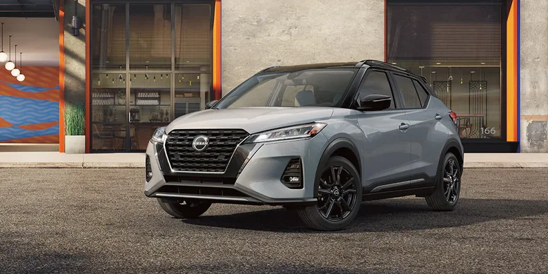 a grey 2024 Nissan Kicks parked diagonally in front of an industrial building.