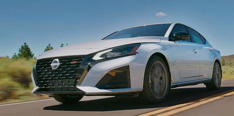 A white 2025 Nissan Altima driving down the road.