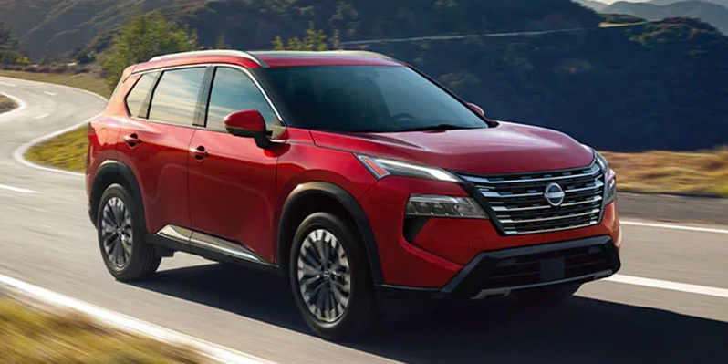 A photo of a 2025 Nissan Rogue driving down the road.