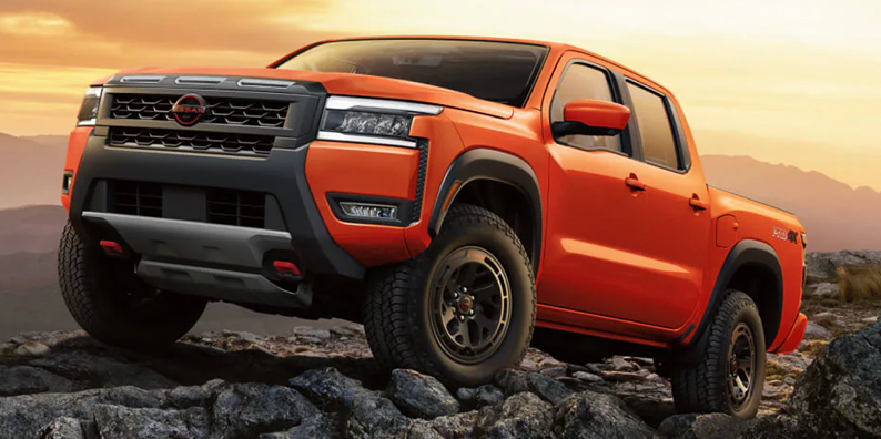 An orange 2026 Nissan Frontier off-roading.